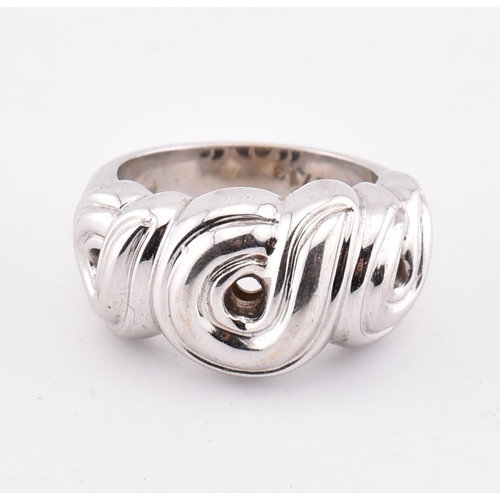 97 - An 18ct white gold Boucheron ring. The 18ct white gold Boucheron ring having a swirled design to tap... 