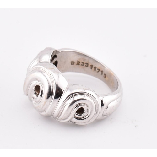 97 - An 18ct white gold Boucheron ring. The 18ct white gold Boucheron ring having a swirled design to tap... 