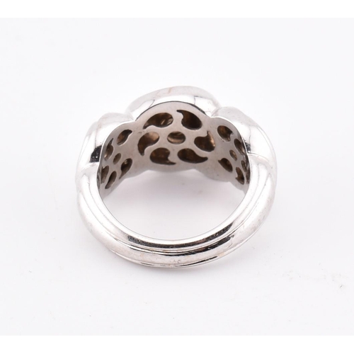 97 - An 18ct white gold Boucheron ring. The 18ct white gold Boucheron ring having a swirled design to tap... 