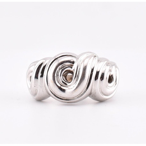 97 - An 18ct white gold Boucheron ring. The 18ct white gold Boucheron ring having a swirled design to tap... 