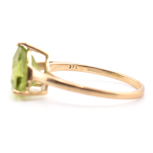 98 - A hallmarked 9ct gold and peridot ring. The ring set with a single trilliant cut peridot to tapering... 