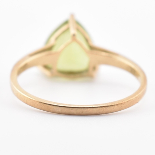 98 - A hallmarked 9ct gold and peridot ring. The ring set with a single trilliant cut peridot to tapering... 