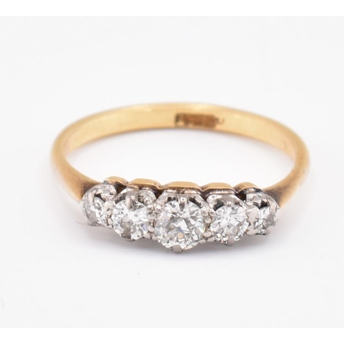 99 - An 18ct gold and diamond five stone ring. The 18ct yellow gold ring set with five claw set graduatin... 