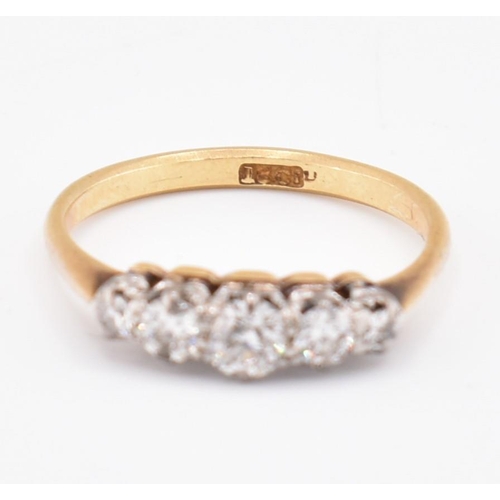 99 - An 18ct gold and diamond five stone ring. The 18ct yellow gold ring set with five claw set graduatin... 