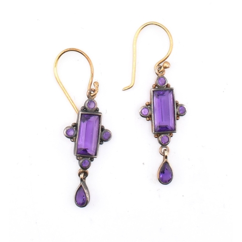 129 - A pair of early 20th century amethyst pendant earrings. The earrings mounted with a central step-cut... 