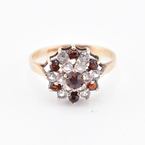 234 - A hallmarked 9ct gold and gem set cluster ring. The 9ct yellow gold ring set with a cluster of round... 