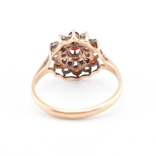 234 - A hallmarked 9ct gold and gem set cluster ring. The 9ct yellow gold ring set with a cluster of round... 