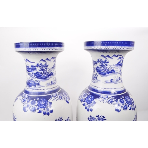 102 - A pair of contemporary Chinese blue and white ceramic vases. The transfer print depicts an Asian Chi... 