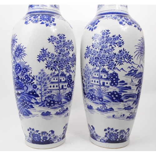 102 - A pair of contemporary Chinese blue and white ceramic vases. The transfer print depicts an Asian Chi... 