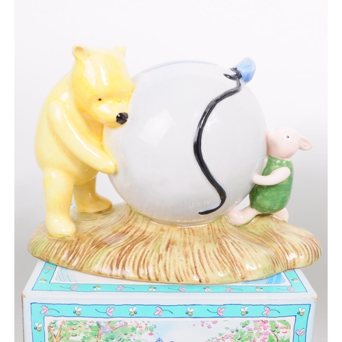 153 - Royal Doulton - Three late 20th century bone china Winnie The Pooh figures. Comprised of Pooh's Blue... 