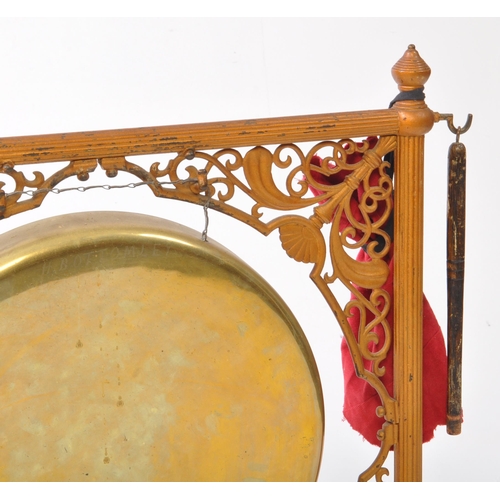 201 - A 20th century dinner gong, featuring a brass gong hanging on a metal chain from a gilt painted cast... 