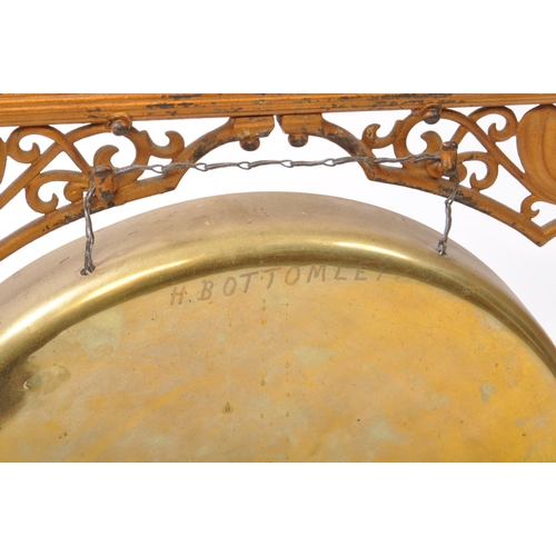 201 - A 20th century dinner gong, featuring a brass gong hanging on a metal chain from a gilt painted cast... 