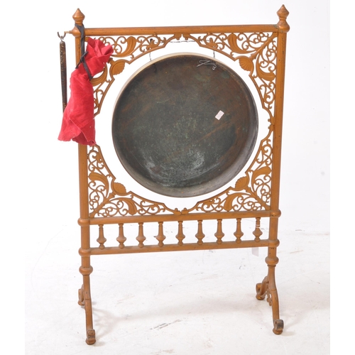 201 - A 20th century dinner gong, featuring a brass gong hanging on a metal chain from a gilt painted cast... 