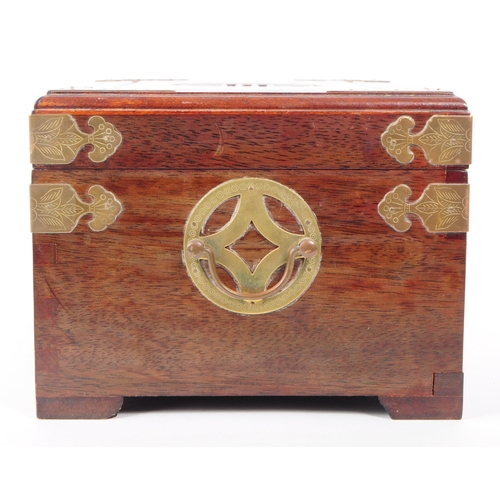 231 - A vintage 20th century Chinese hardwood jewellery box / chest. Having brass mounts, carved centre mo... 