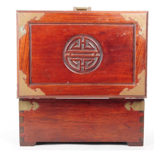 231 - A vintage 20th century Chinese hardwood jewellery box / chest. Having brass mounts, carved centre mo... 