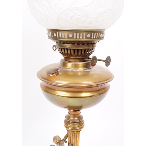 391 - Early 20th century brass columnar oil lamp mounted on four scrolled feat with a brass cherub figure ... 