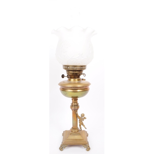 391 - Early 20th century brass columnar oil lamp mounted on four scrolled feat with a brass cherub figure ... 