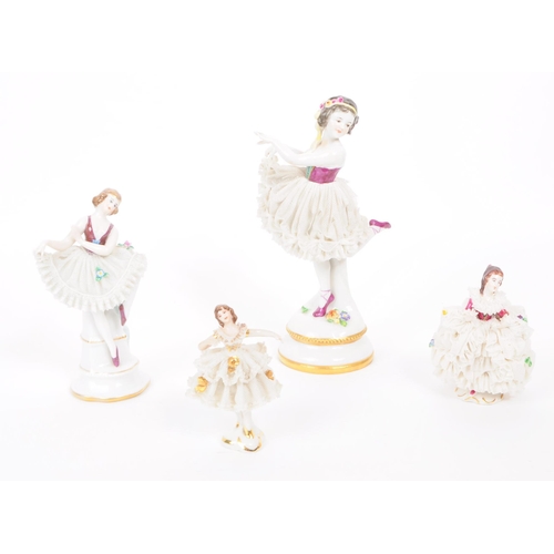 63 - Four vintage 20th century German porcelain dancer figures, in lace dresses and hand painted to the b... 