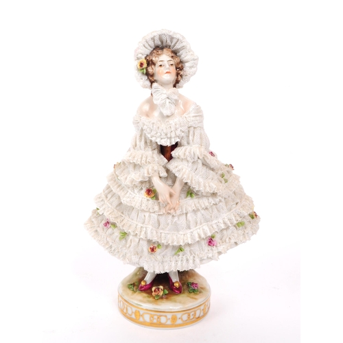 72 - Volkstedt Rudolstadt - An early 20th century porcelain lady figurine.  Featuring a lace dress and bo... 