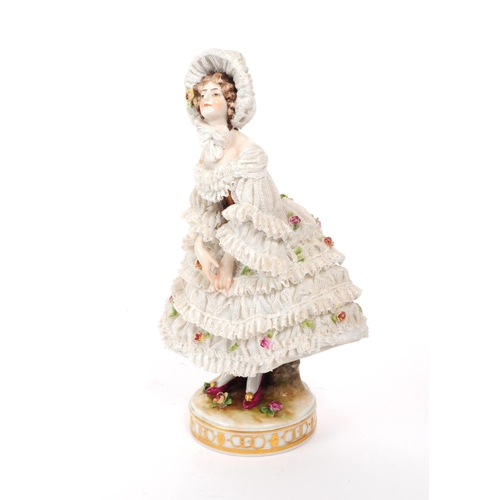 72 - Volkstedt Rudolstadt - An early 20th century porcelain lady figurine.  Featuring a lace dress and bo... 