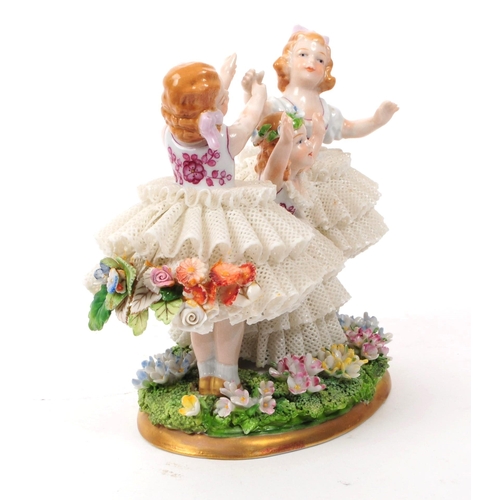 81 - Sitzendorf - 20th century German porcelain children figurine. Featuring three children in lace dress... 