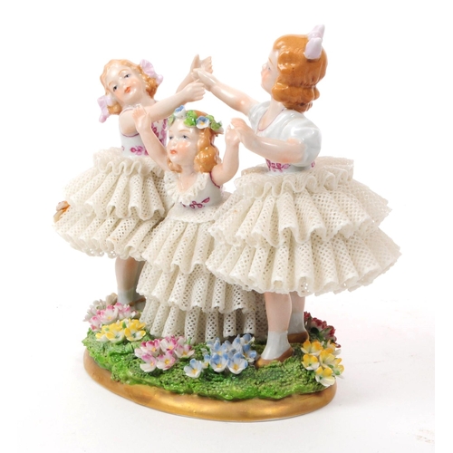 81 - Sitzendorf - 20th century German porcelain children figurine. Featuring three children in lace dress... 