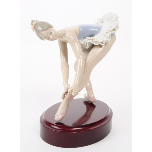 83 - Lladro - Late 20th century porcelain lady Ballerina figure in a stretching pose. Dressed in a lace s... 