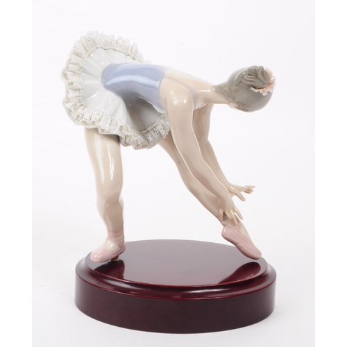 83 - Lladro - Late 20th century porcelain lady Ballerina figure in a stretching pose. Dressed in a lace s... 