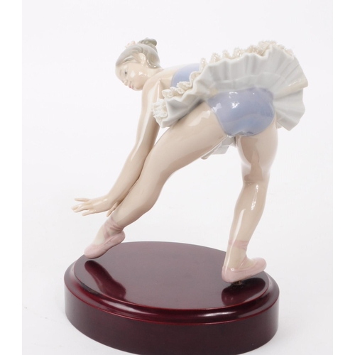 83 - Lladro - Late 20th century porcelain lady Ballerina figure in a stretching pose. Dressed in a lace s... 