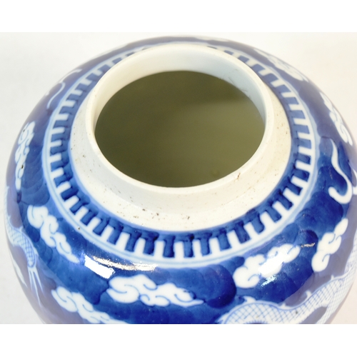 21 - A 19th century Chinese blue and white porcelain ginger jar, decorated with two dragons flying amongs... 