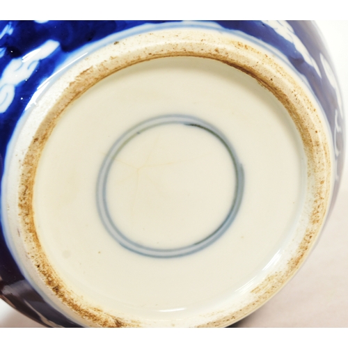 21 - A 19th century Chinese blue and white porcelain ginger jar, decorated with two dragons flying amongs... 