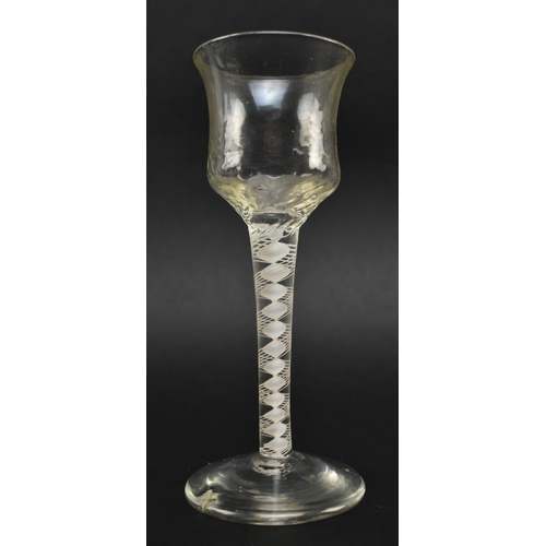 130 - A mid 18th century George II circa 1765 wine glass. The wine glass with textured ogee bowl over doub... 