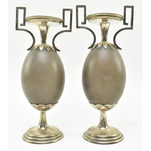 131 - A pair of early 20th century Australian vases, each formed from central emu egg. Each vase featuring... 