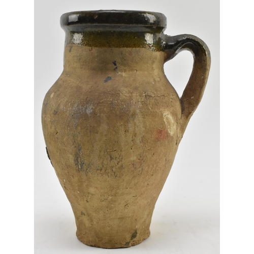 45 - A circa 14th to 16th century earthenware clay water jug / handled vase. The jug having mottled tudor... 