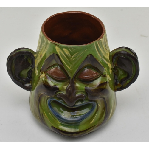 47 - C. H. Brannam Pottery - an early 20th century circa 1901 hand painted grotesque twin faced vase, pos... 