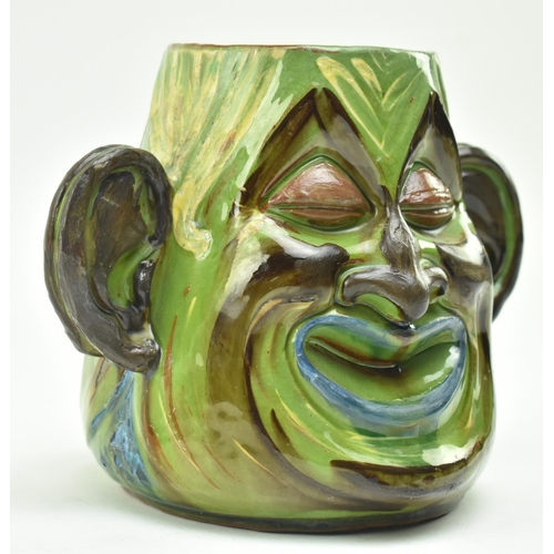 47 - C. H. Brannam Pottery - an early 20th century circa 1901 hand painted grotesque twin faced vase, pos... 