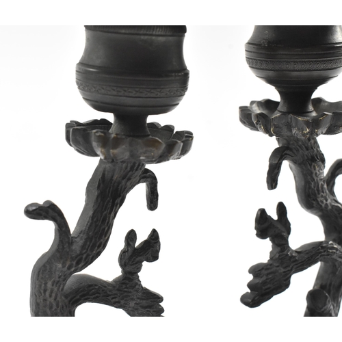 82 - A pair of early 19th century cast iron ornate table candlesticks. The candle holders having a floral... 