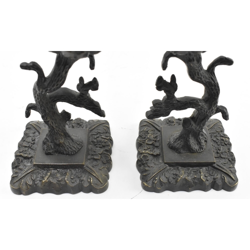 82 - A pair of early 19th century cast iron ornate table candlesticks. The candle holders having a floral... 