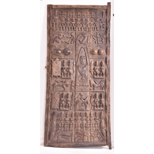 206 - An African Dogon three panel granary door from Mali. This highly decorated door having carvings of a... 