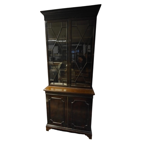 216 - A late 19th century mahogany library bookcase. The bookcase having a pediment top with blind fret wo... 