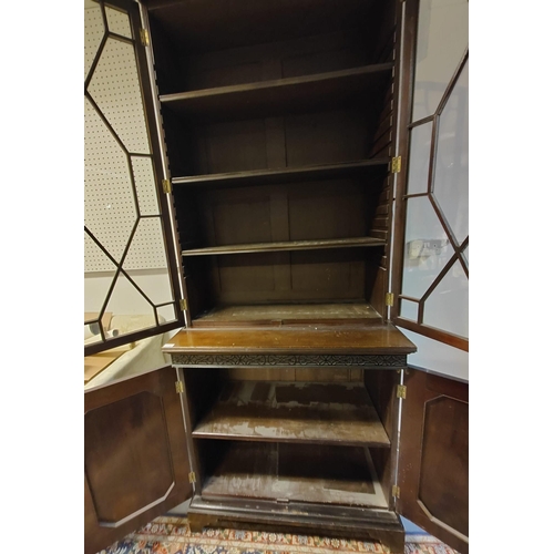 216 - A late 19th century mahogany library bookcase. The bookcase having a pediment top with blind fret wo... 