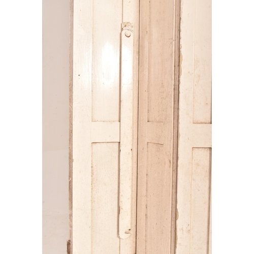 254 - A matching pair of 19th century George III bifold white painted window shutters. Each of slender for... 