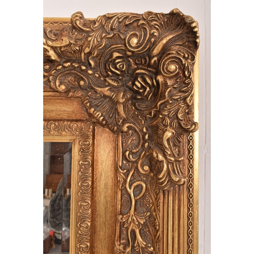 255 - A large Baroque inspired 19th century gilt wood ornate overmantel wall hanging mirror. The mirror ha... 