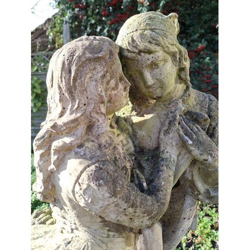 313 - A 20th century reproduction reconstituted stone classical garden statue of two lovers entwined. Rais... 