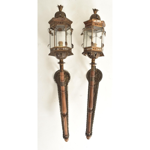 330 - A pair of Continental early 20th century embossed bronzed metal &  wooden wall lanterns / lights... 