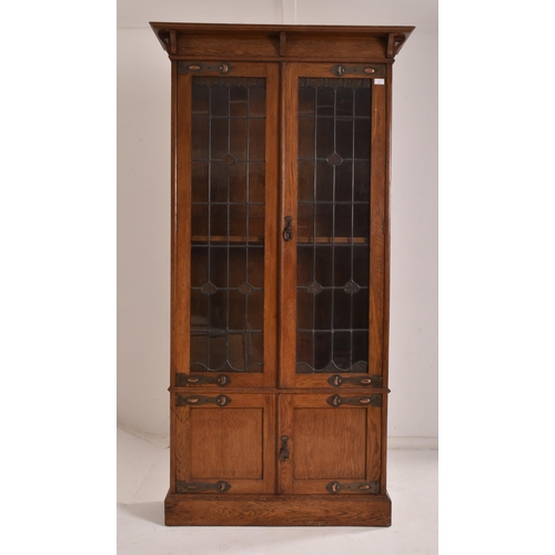 347 - An Edwardian, circa 1910 Arts & Crafts oak upright pedestal library bookcase cabinet. The cabine... 