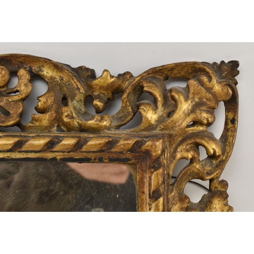 350 - An Italian 19th century Florentine gilt wood & gesso wall mirror. The mirror frame intricately c... 