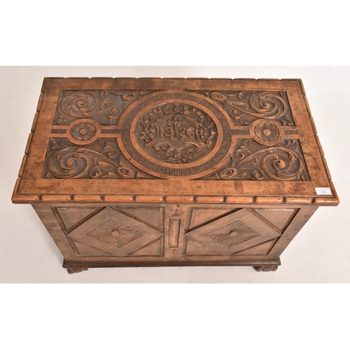 351 - An early 20th century Arts & Crafts 1926 carved walnut coffer chest. The coffer having an intric... 