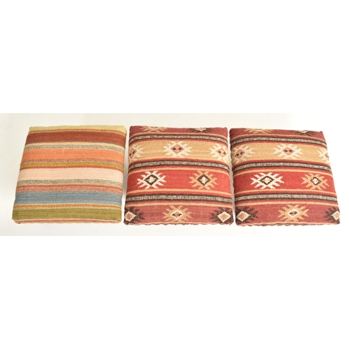 379 - A set of three country house Indian Zanskar Kilim footstools / seats. Each with multi-coloured padde... 