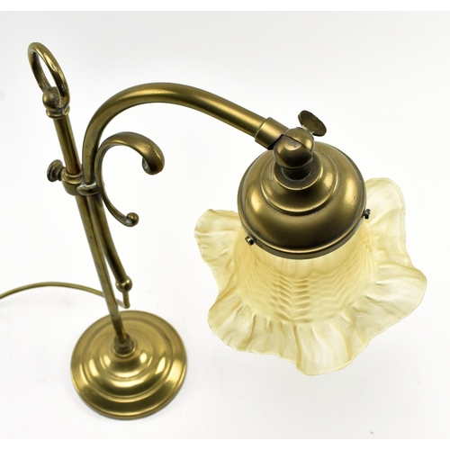 397 - An Art Nouveau early 20th century brass & glass desk table coaching lamp. The lamp having a flow... 